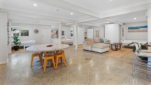 A spacious living area with a round wooden table, white sofas, and a large window with a view. - 5 Unit Property - Lots of space and privacy for the whole group (Point Lookout)