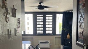 Une cuisine avec un coin repas, un ventilateur de plafond et une vue par la fenêtre.