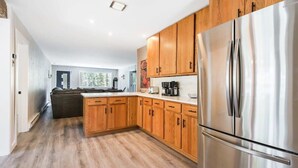 Une cuisine moderne avec des meubles en bois, des appareils en acier inoxydable et un grand îlot central.