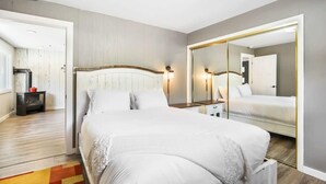 Une chambre à coucher avec un grand lit, un miroir et une tête de lit en bois.