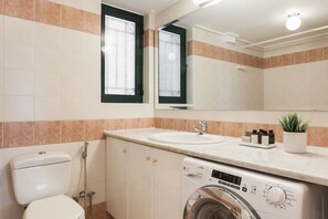 A bathroom with a toilet, sink, and washing machine. - Top-Class 2BR Apartment in Marousi (Marousi)