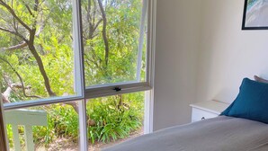 A bedroom with a large window, a bed, and a nightstand. - Tyrone Beach Escape (Rye)