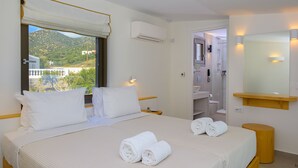 Une chambre d’hôtel avec un lit, une salle de bain et une vue sur un paysage montagneux.