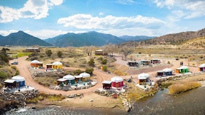 Yurts with outdoor seating and a river. - Orange Sunset (Cañon City)