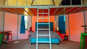 A tent with a bunk bed, a ladder, and a small table with a chair. - Orange Sunset (Cañon City)