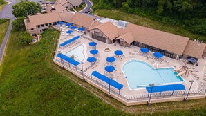 Un grand complexe hôtelier doté de plusieurs piscines, de transats et de parasols.