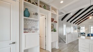 A spacious kitchen with white cabinetry, a wooden ceiling, and a view of the living area. - Beautiful golf course view home at Palmilla Beach Resort with resort pool (Port Aransas)