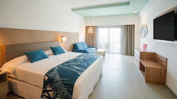 Una habitación de hotel con una cama grande, un escritorio, una silla y un televisor.