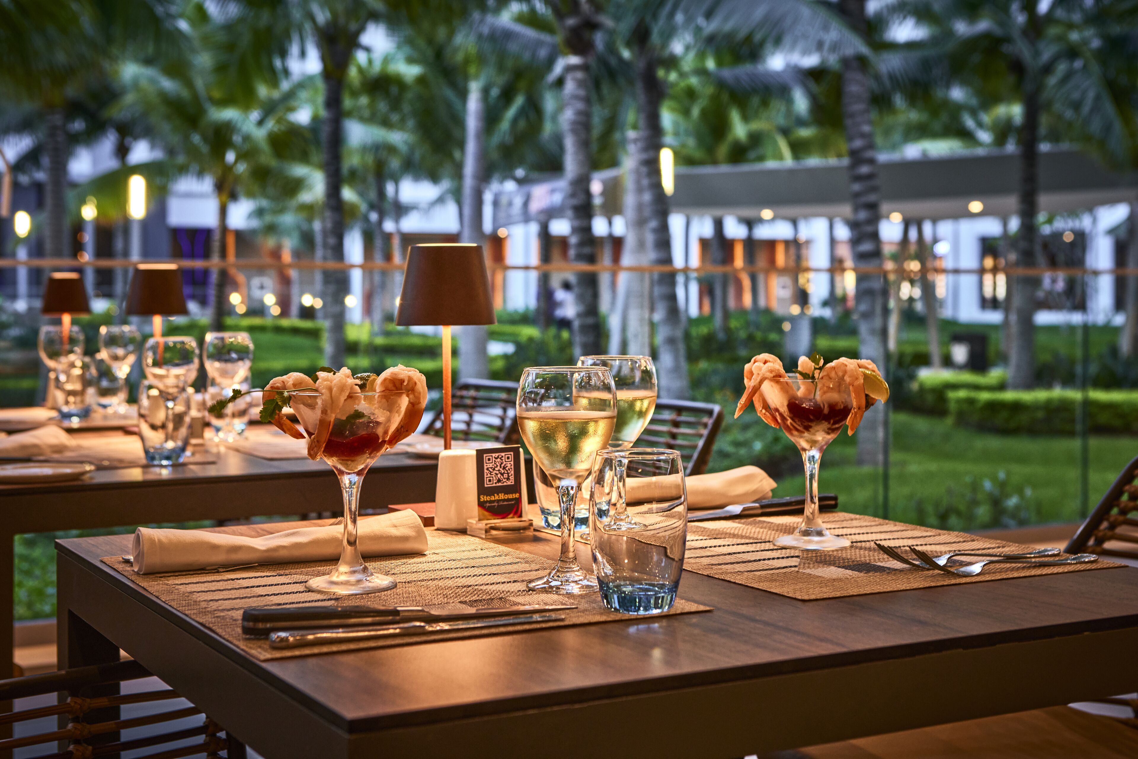 A restaurant table set with wine glasses, a water glass, and a steakhouse menu.