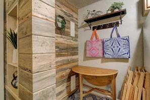 Cozy retreat with a wooden table and chairs, a shelf with a potted plant, and a hook for your belongings.