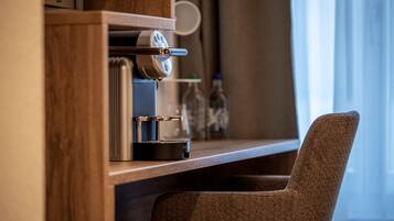 Una cafetera moderna sobre una encimera de madera, con una silla frente a ella.