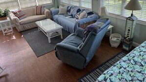 A living room with a sofa, a coffee table, and a patterned rug.