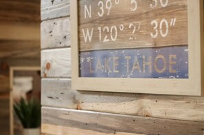 Een houten bord met coördinaten en de naam 'LAKE TAHOE'.
