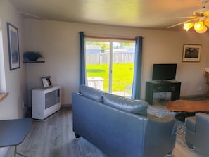 Relax in this stylish living room with a sofa, flat-screen TV, and ceiling fan.