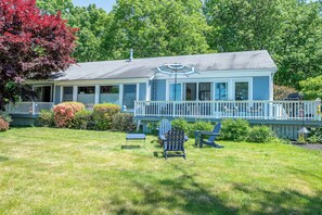A house with a porch, a lawn, and a mailbox. - Sand Dollar - Dog-friendly, Steps to the Ocean, Stunning Sunsets (Harpswell)