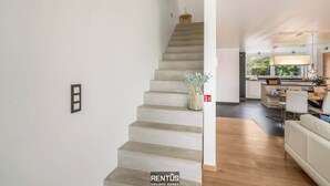 Un intérieur moderne avec un escalier menant à une cuisine.