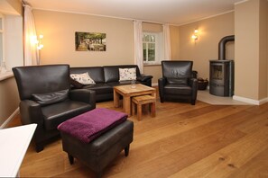 A cozy living room with a sofa set, a coffee table, and a fireplace.