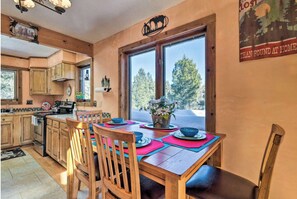 Enjoy cooking in this well-equipped kitchen with a central island and large window offering a view of the surrounding forest.