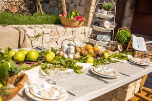 A table set with fruits, eggs, and a tiered stand with cups and a potted plant.