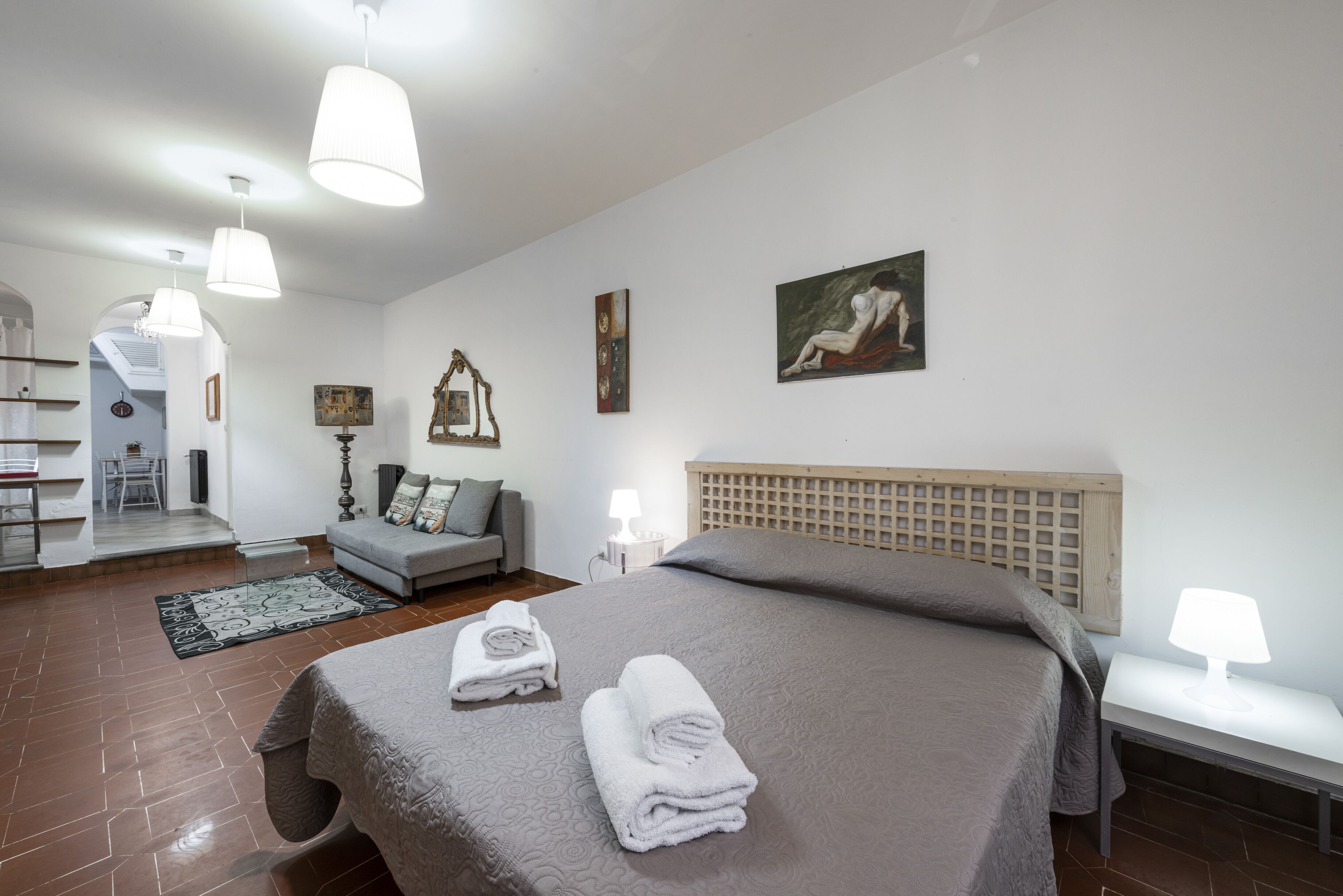 Une chambre d’hôtel avec un grand lit, un canapé, un coin repas et un escalier.