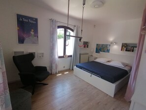 Un dormitorio con cama, una silla, un radiador, un mapa en la pared y un cartel.