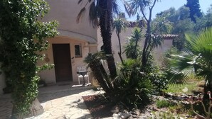 A stone pathway leading to a building with a door and a bench. - Villa with private pool - garden - family vacations near the sea (La Garde)