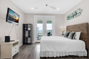 A bedroom with a bed, a TV, a desk, a wardrobe, and a balcony with a view. - 🏖️Stunning Gulf Views-Steps to Beach-Pet Friendly-3BR Nonni n' Poppy's (Navarre)
