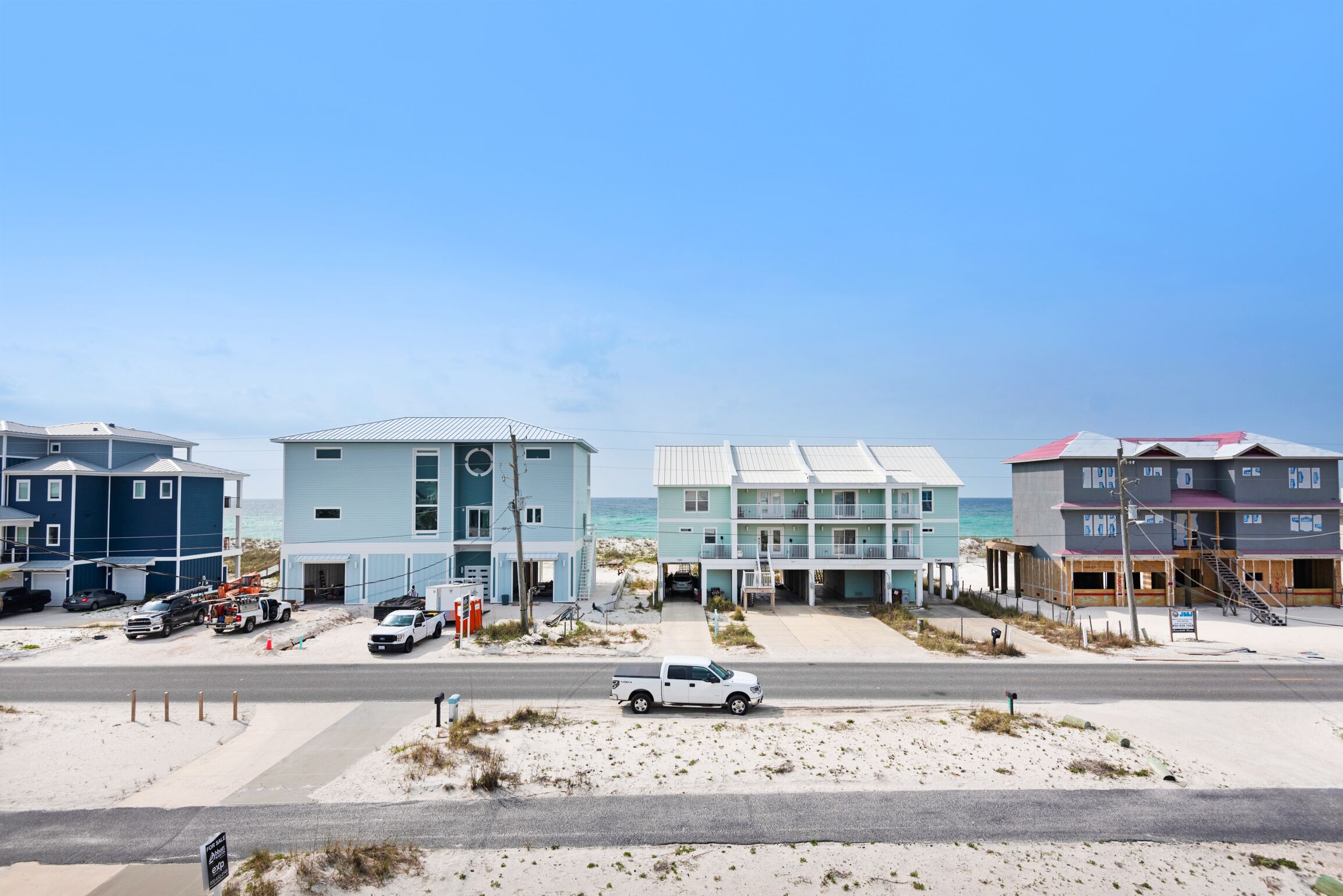 A beachfront hotel with multiple buildings, a road, and beach access.