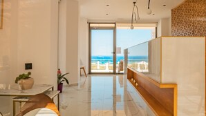 Um hall de hotel moderno com piso de mármore, uma recepção e vista para a praia.