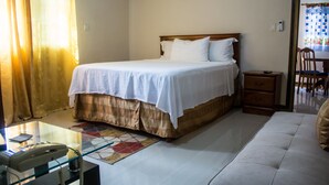 Un dormitorio con cama, mesita de noche y una silla.