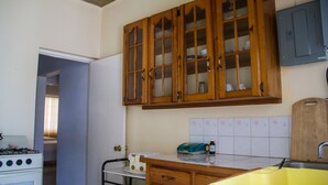 Una cocina con armarios de madera, estufa, pileta y encimera.