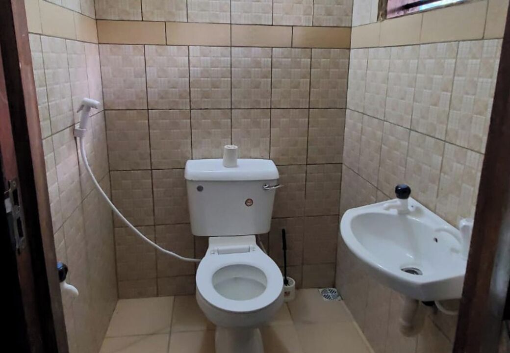 Ein kleines Badezimmer mit Toilette, Bidet und einem wandmontierten Waschbecken.
