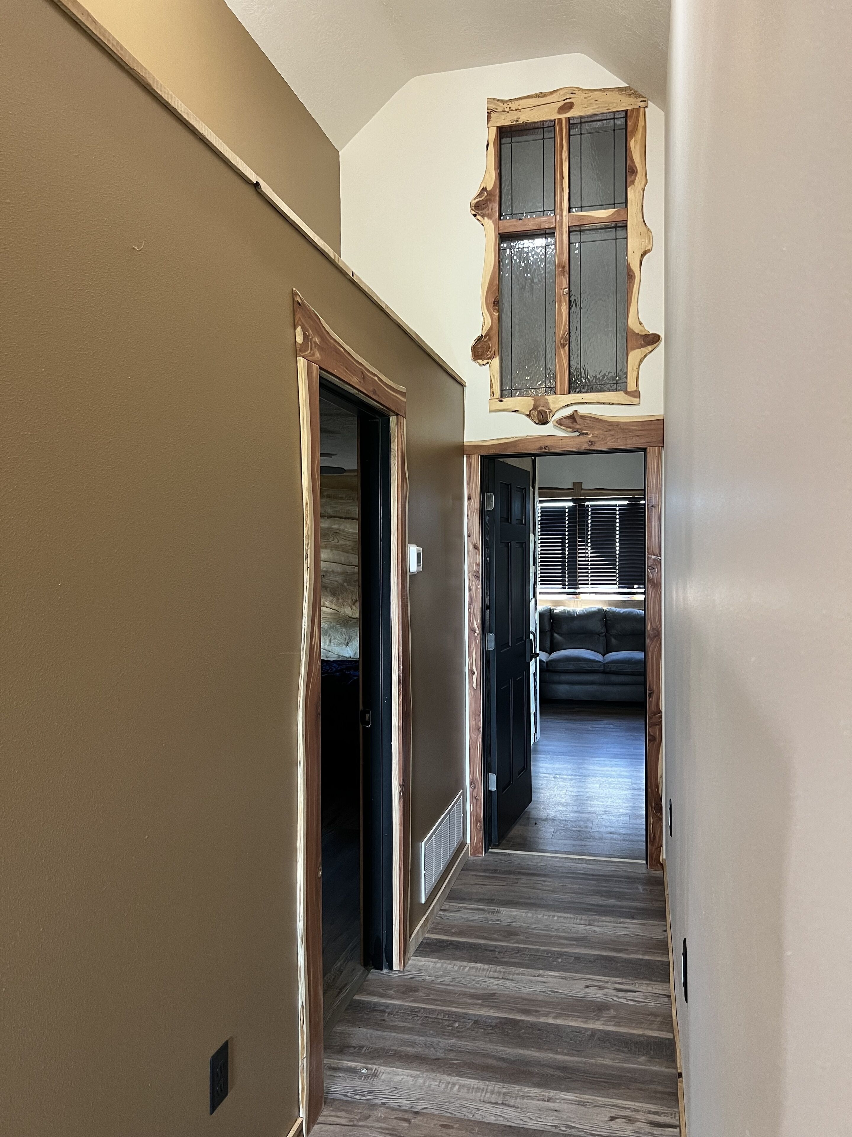 Un corridoio stretto con pavimento in legno e soffitto alto.