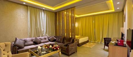 A modern living room with a sofa, armchairs, a coffee table, and a desk.