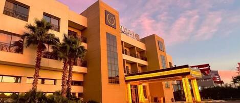 Ein Hotel mit modernem Design, das eine markante, überdachte Eingangspartei und eine Uhr zeigt.