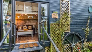 A cozy cabin with a wooden deck, a bench, and a sign indicating it's an 'oak tree lodge.' - Two-Level Shepherd`s Hut · Sleeps 4 with Kids` Den · Fire Pit near Dartmouth (Dartmouth)