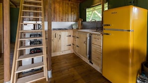 A kitchen with wooden cabinets, a yellow refrigerator, a sink, and a ladder. - Awe Inspiring two storey tent (Crowhurst)