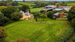 A rural property with a large lawn, a house, and a barn.