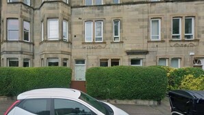 A multi-story building with a symmetrical facade, large windows, and a well-maintained hedge in front. - Newly renovated 1BDR APT near charming Newhaven (Edinburgh)