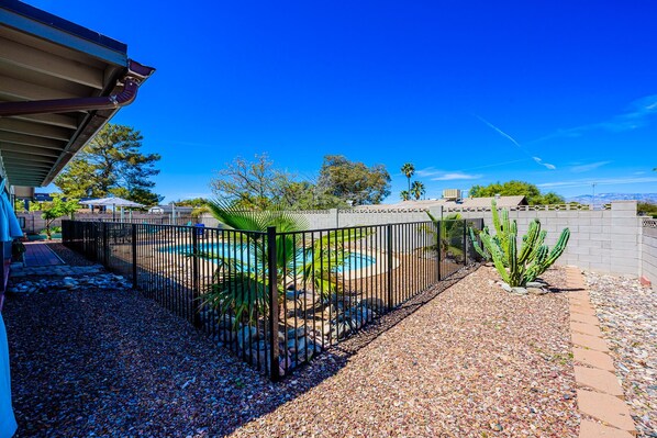 A backyard with a swimming pool, a cactus, and a fence. - Private Pool Oasis Getaway ~ Hot Tub ~ BBQ ~ Great Location! (Tucson)