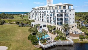 A multi-story hotel with a pool, outdoor seating, and a view of the ocean. - KIVA ON THE GULF: PRIVATE BEACH, PREMIER GOLF COURSE, AND 3 POOLS! (Gulf Shores)