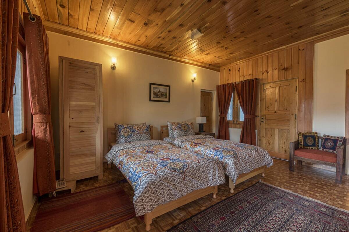 A wooden-paneled bedroom with a bed, a wooden wardrobe, and a bench.