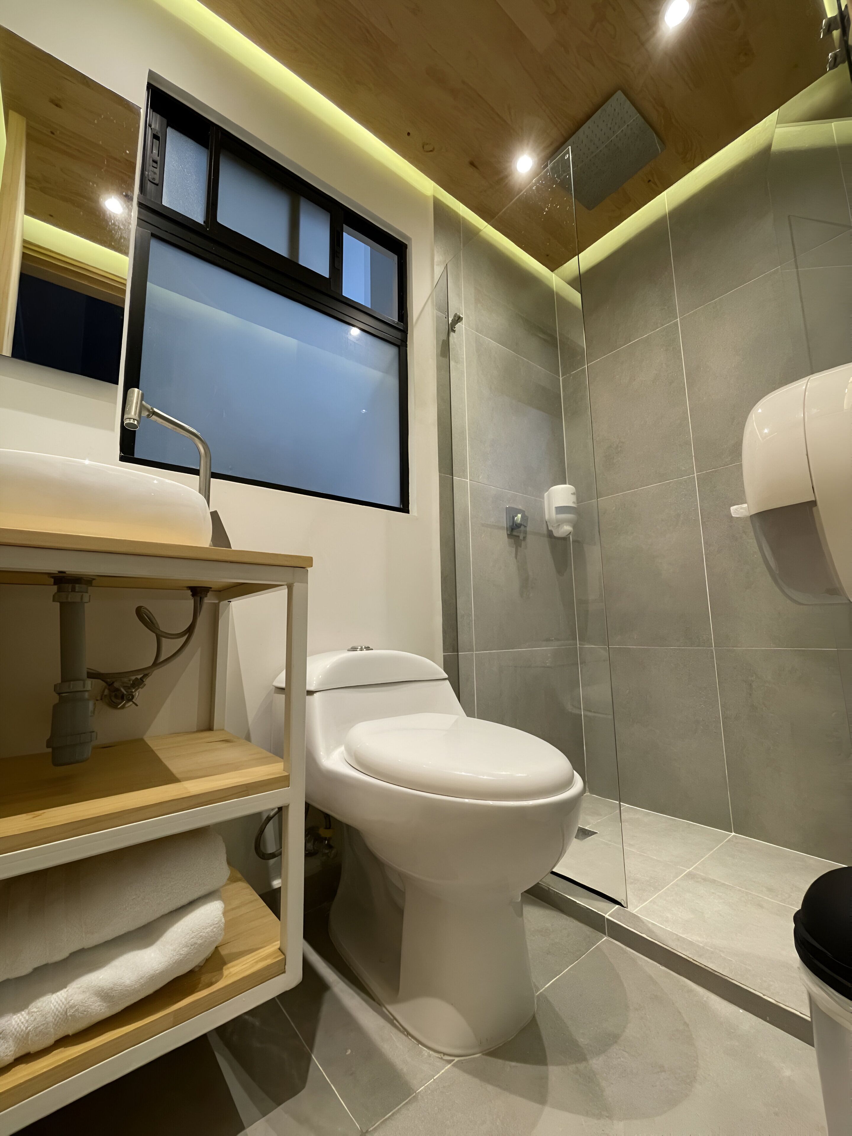 Un baño moderno con inodoro, lavamanos y ducha.