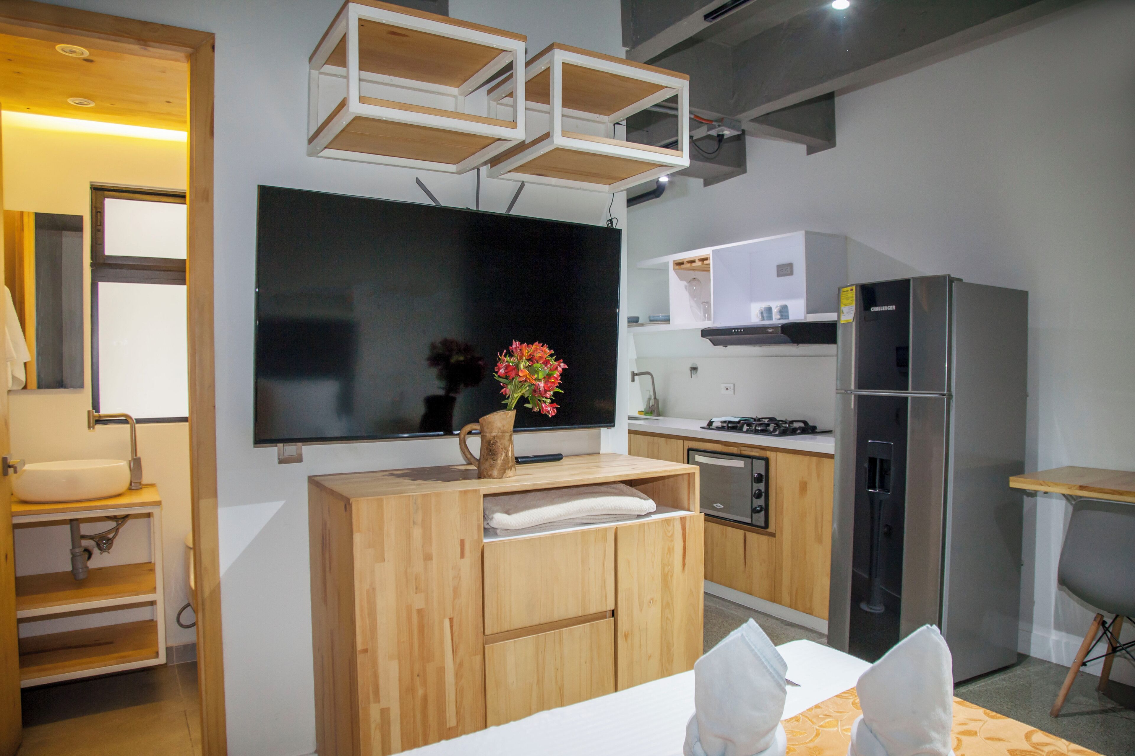 Een moderne keuken met houten kastjes, een ingebouwde oven en een roestvrijstalen koelkast.