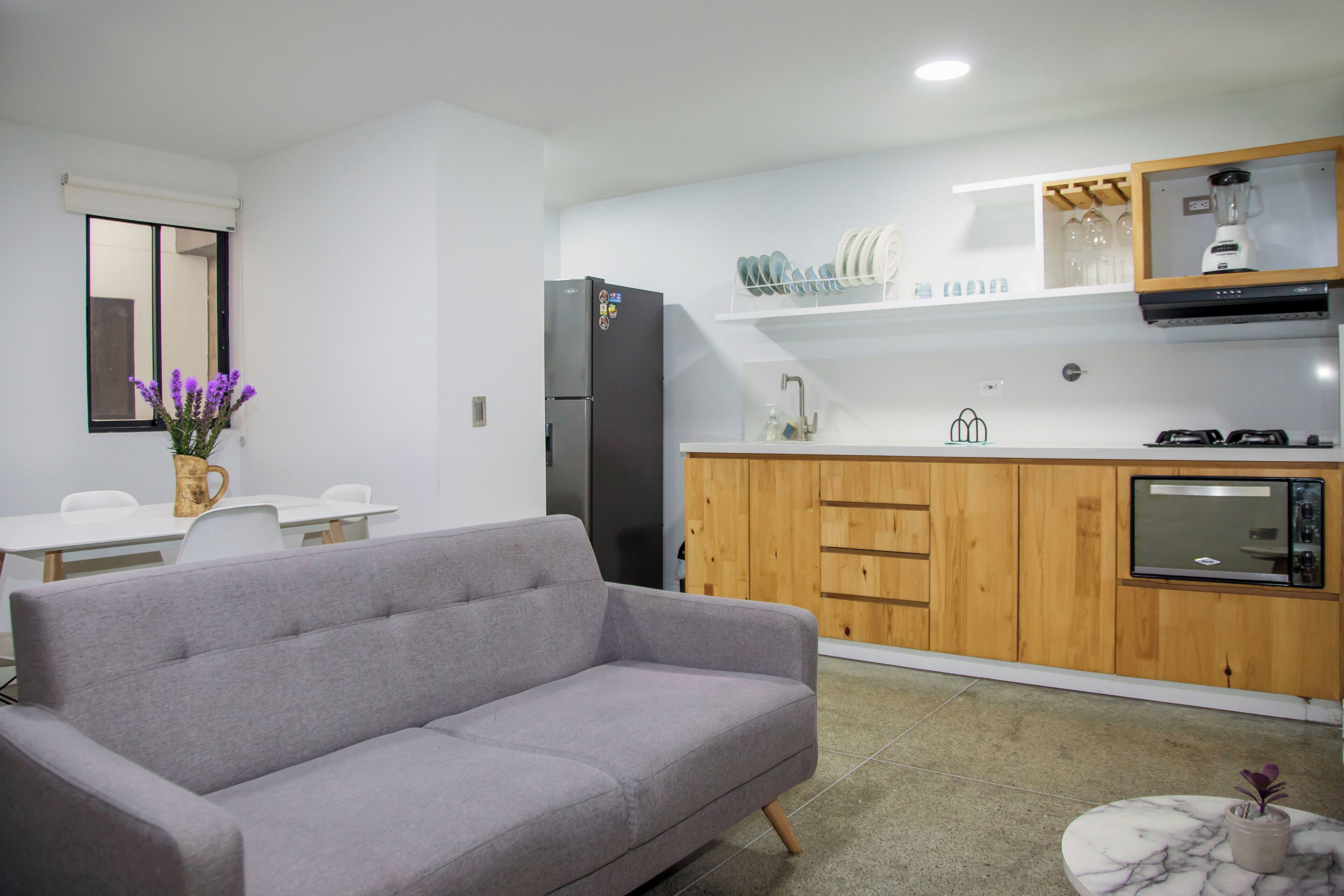 A modern kitchen with wooden cabinets, a built-in oven, and a refrigerator.