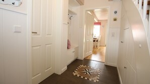 A hallway with white doors, a star-patterned rug, and a wooden ceiling.