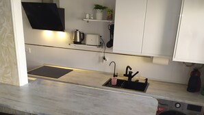Una cocina moderna con barra, lavadora y lavaplatos.