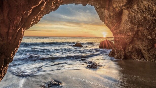 A natural rock formation with a view of the ocean at sunset. - OCEAN VIEW BUNGALOW - MALIBU, CA (Malibu)
