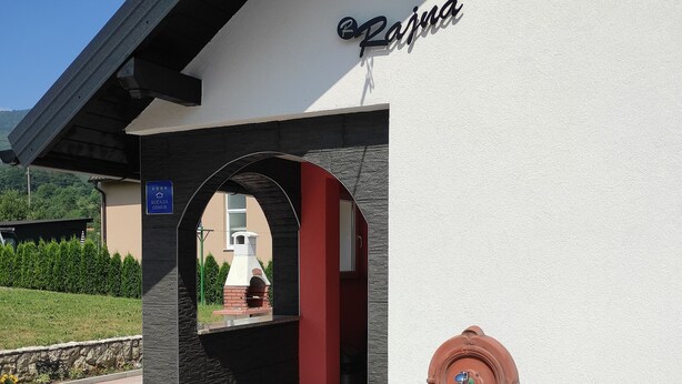 A building entrance with a sign reading "Rajna".