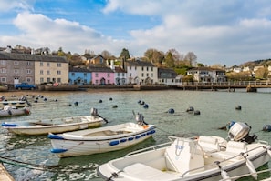 Un port où plusieurs bateaux sont amarrés, un pont et, au loin, des bâtiments aux couleurs vives.